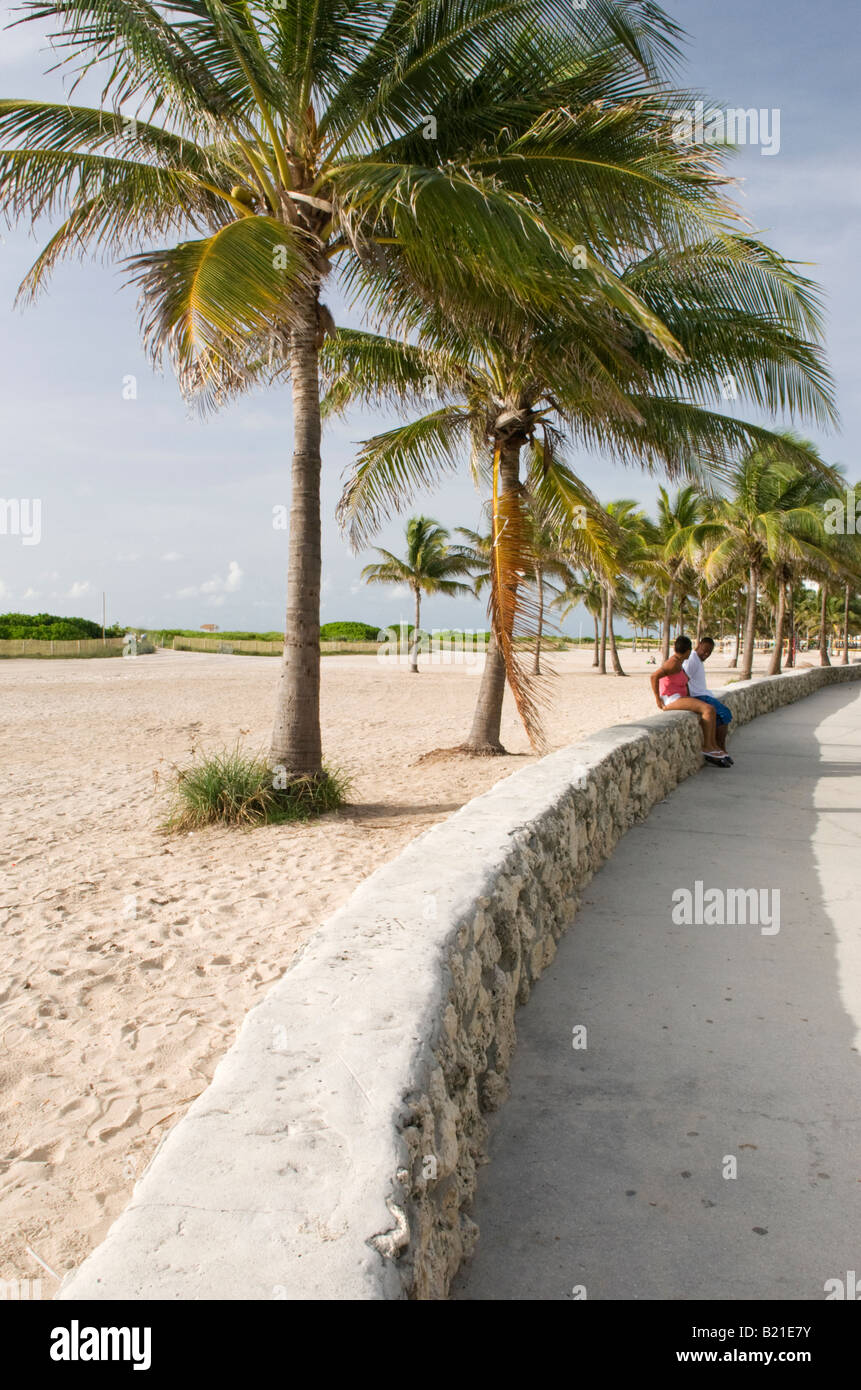 Couple Relaxing under Palm Trees in Lummus Park in South Beach Miami Stock Photo