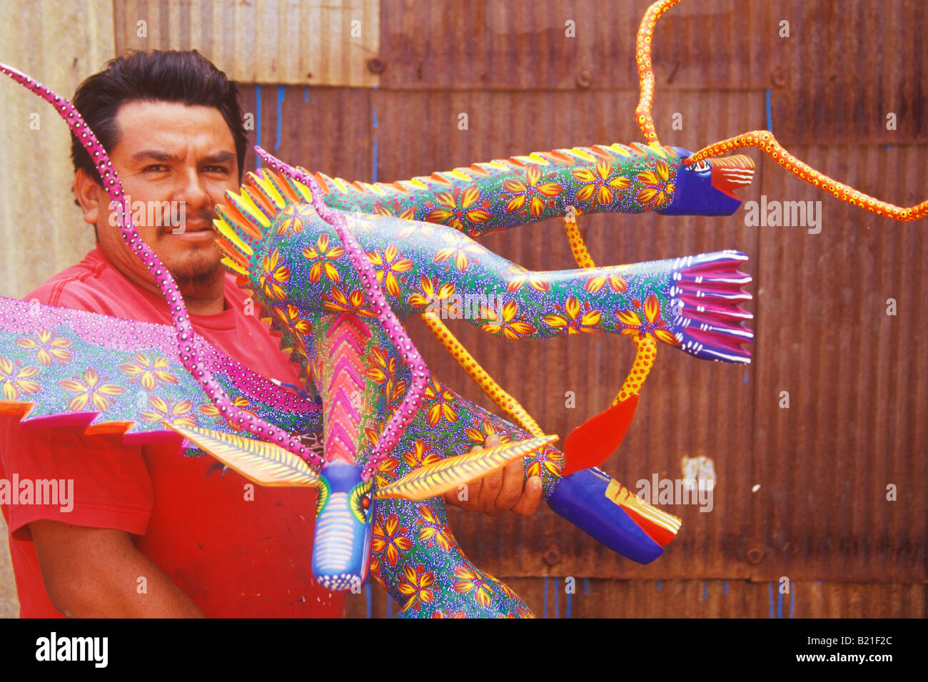 artist Francisco Fabian Ojeda with a carved wooden alebrije San