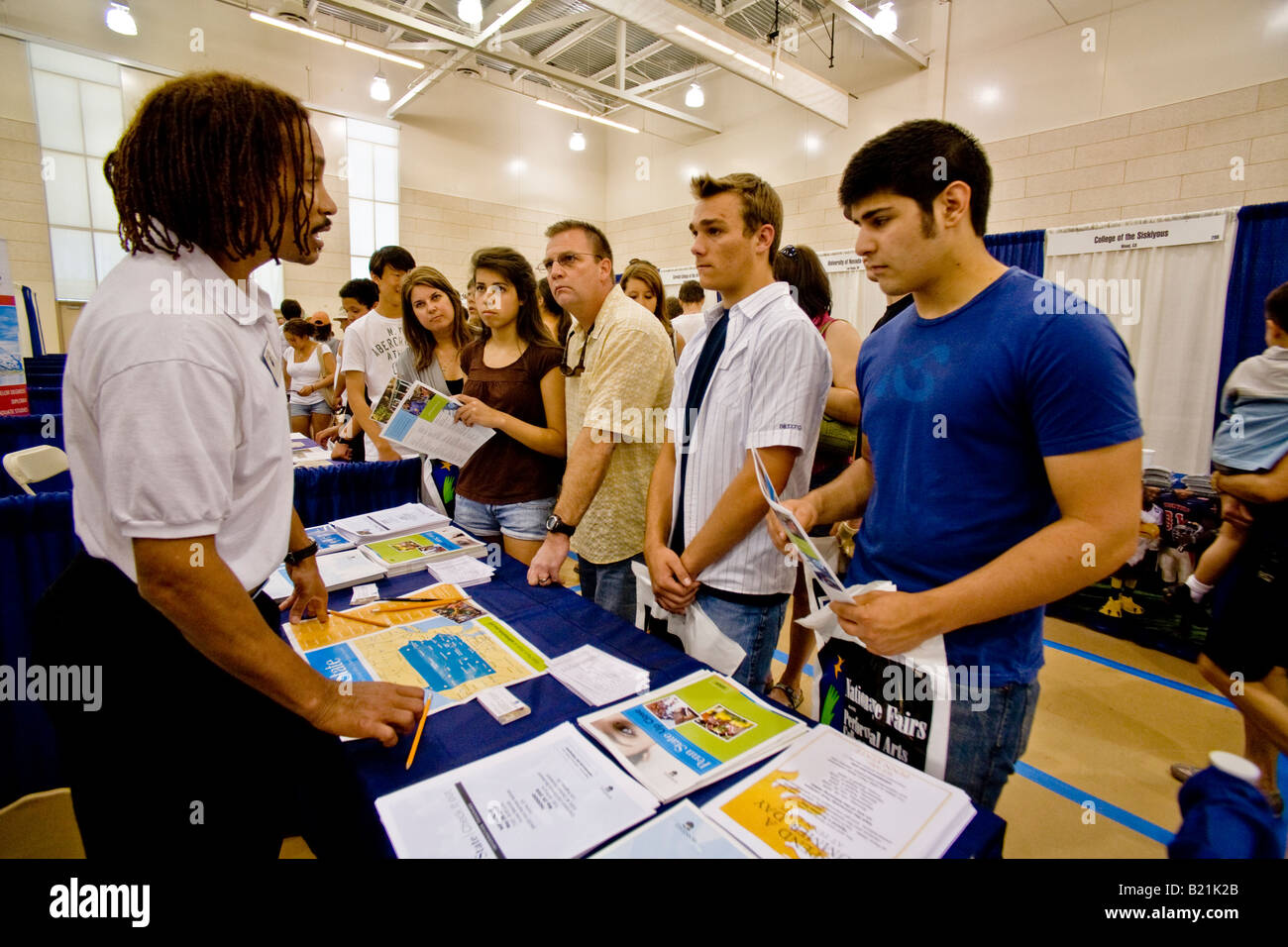 A college representative advises high school students and their parents at a college fair in Los Angeles Stock Photo