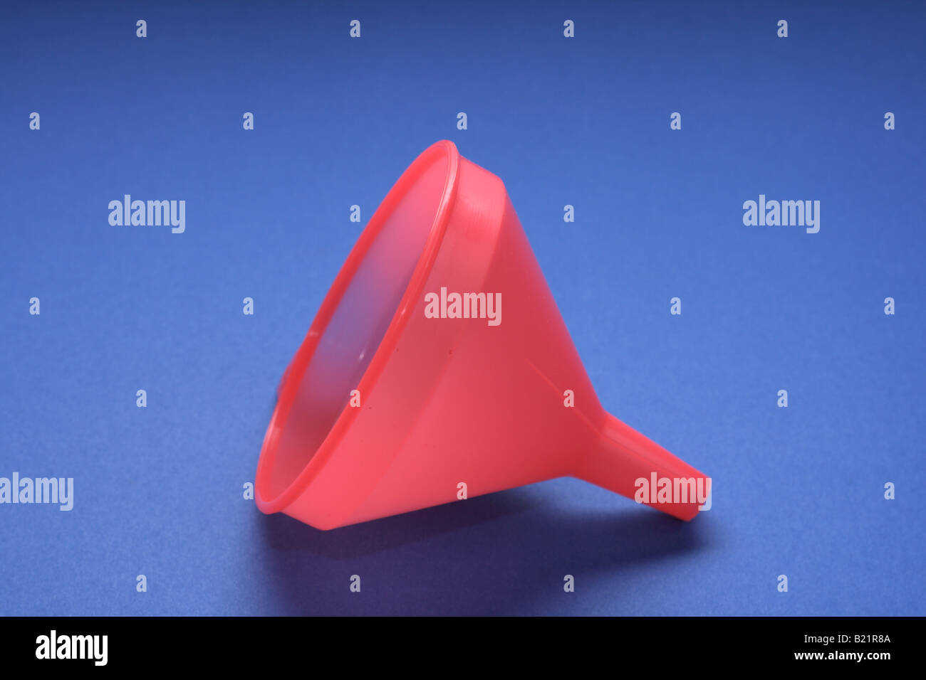 red colored cone shaped funnel used for pouring liquid into small hole