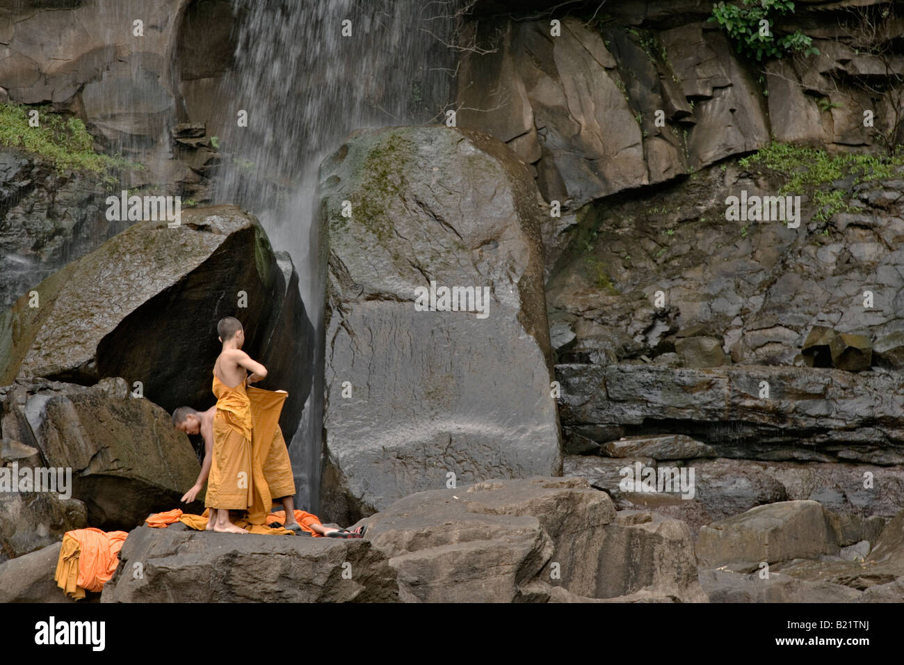 Young Buddhist monks bathe in Tad Puk waterfall, Attapeu, Laos Stock