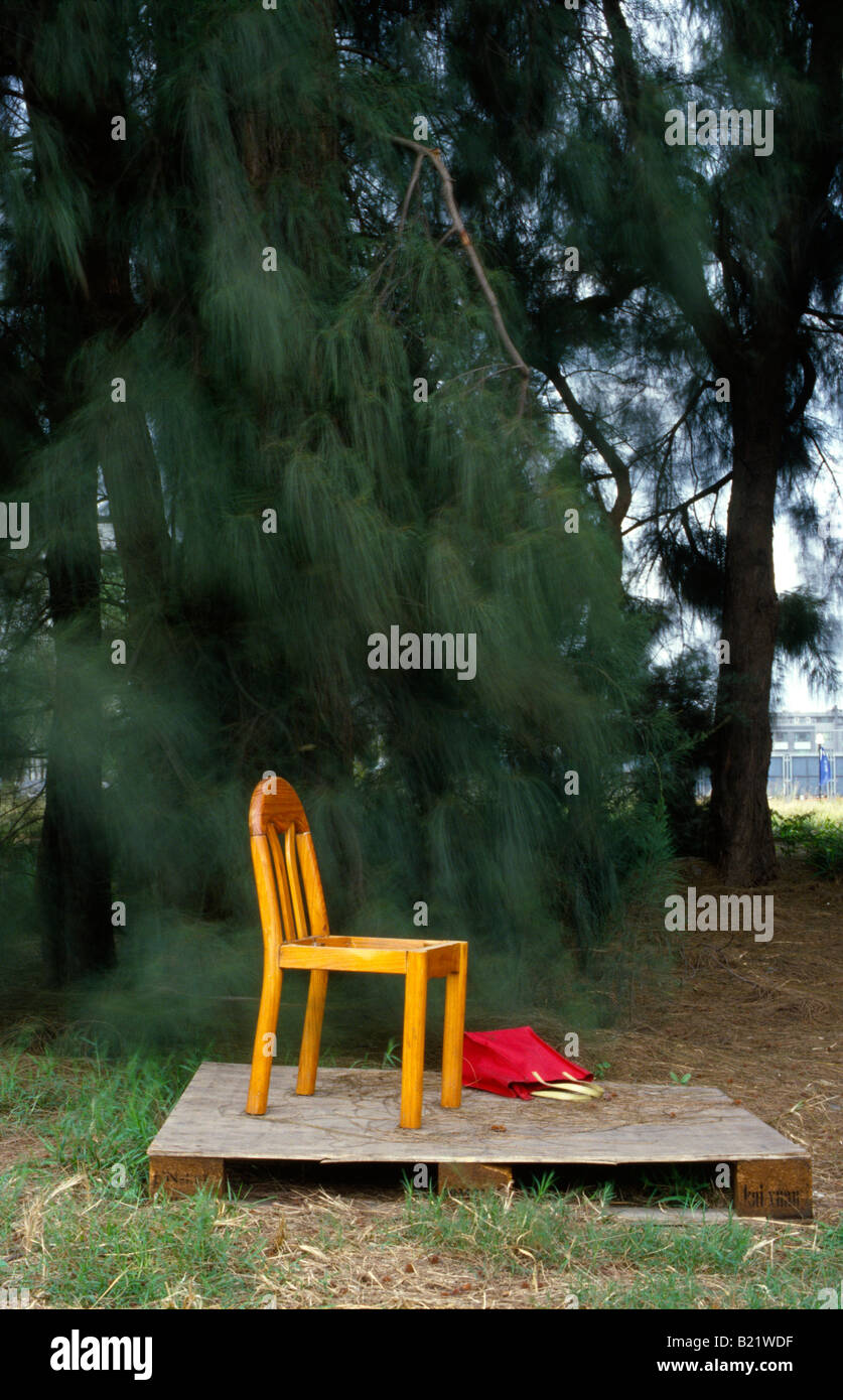 An old seatless chair on a pallet with a bag next to it Stock Photo