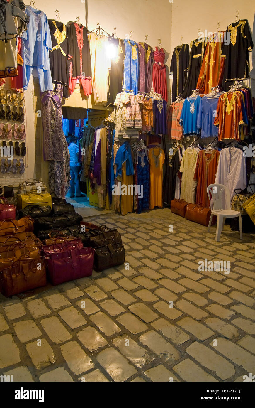 Vertical night time view of the outside of traditional Tunisian handicraft shop packed full of souvenirs for tourists Stock Photo
