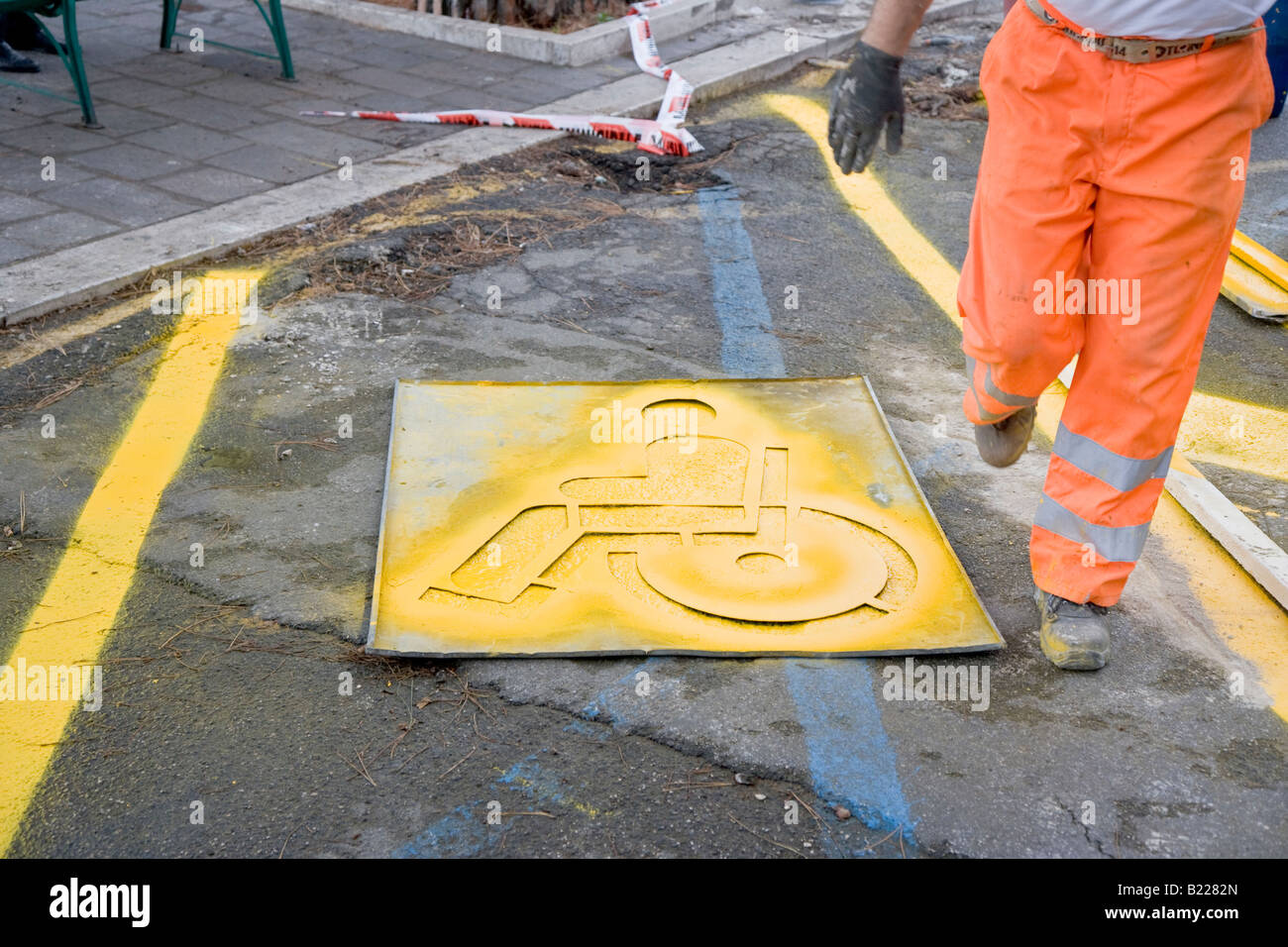 workman-painting-disabled-parking-space-sign-with-stencil-lazio-italy