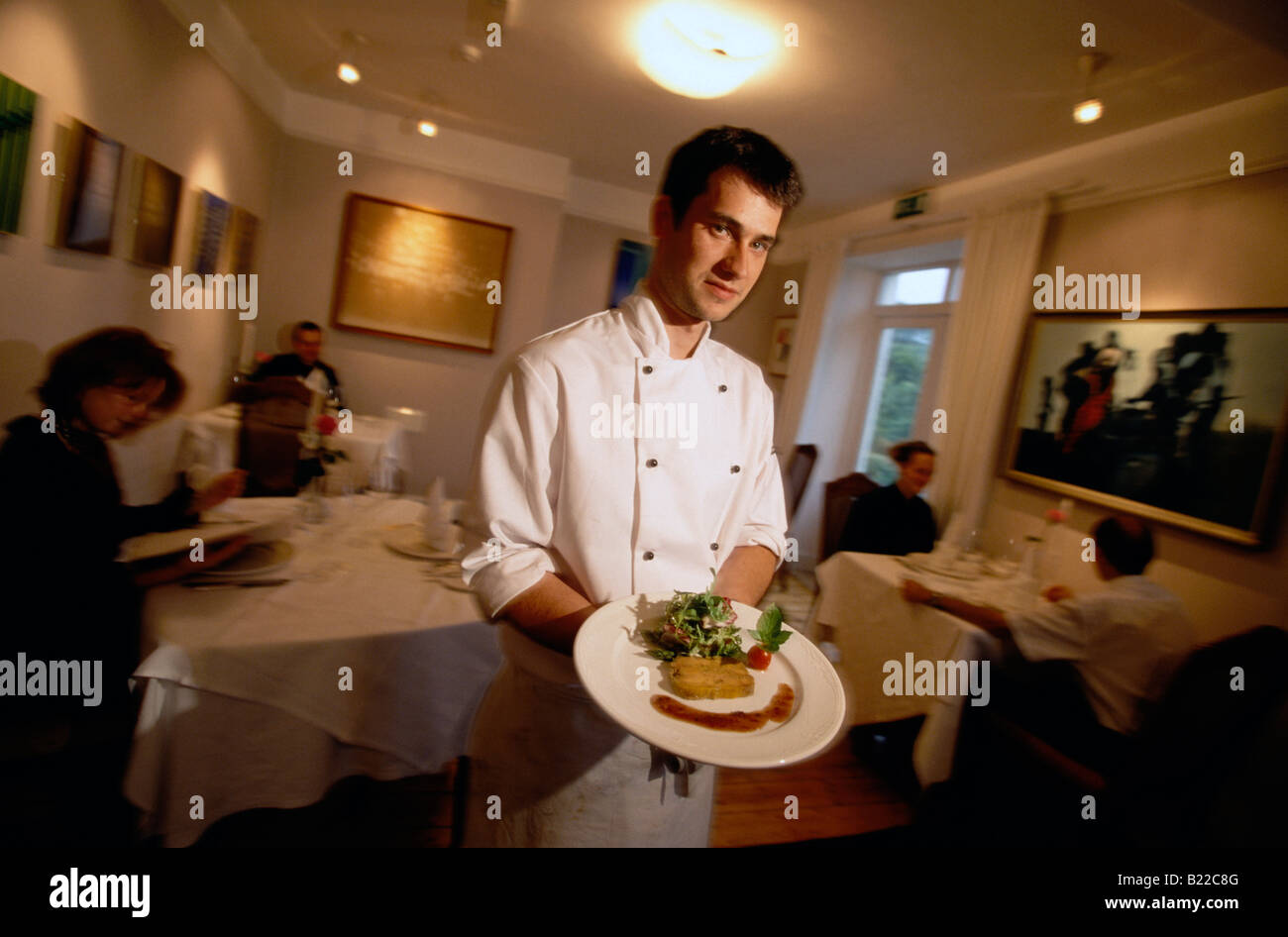 Waiter presenting plate at the Toddies Restaurant Kinsale County West Cork Ireland Stock Photo