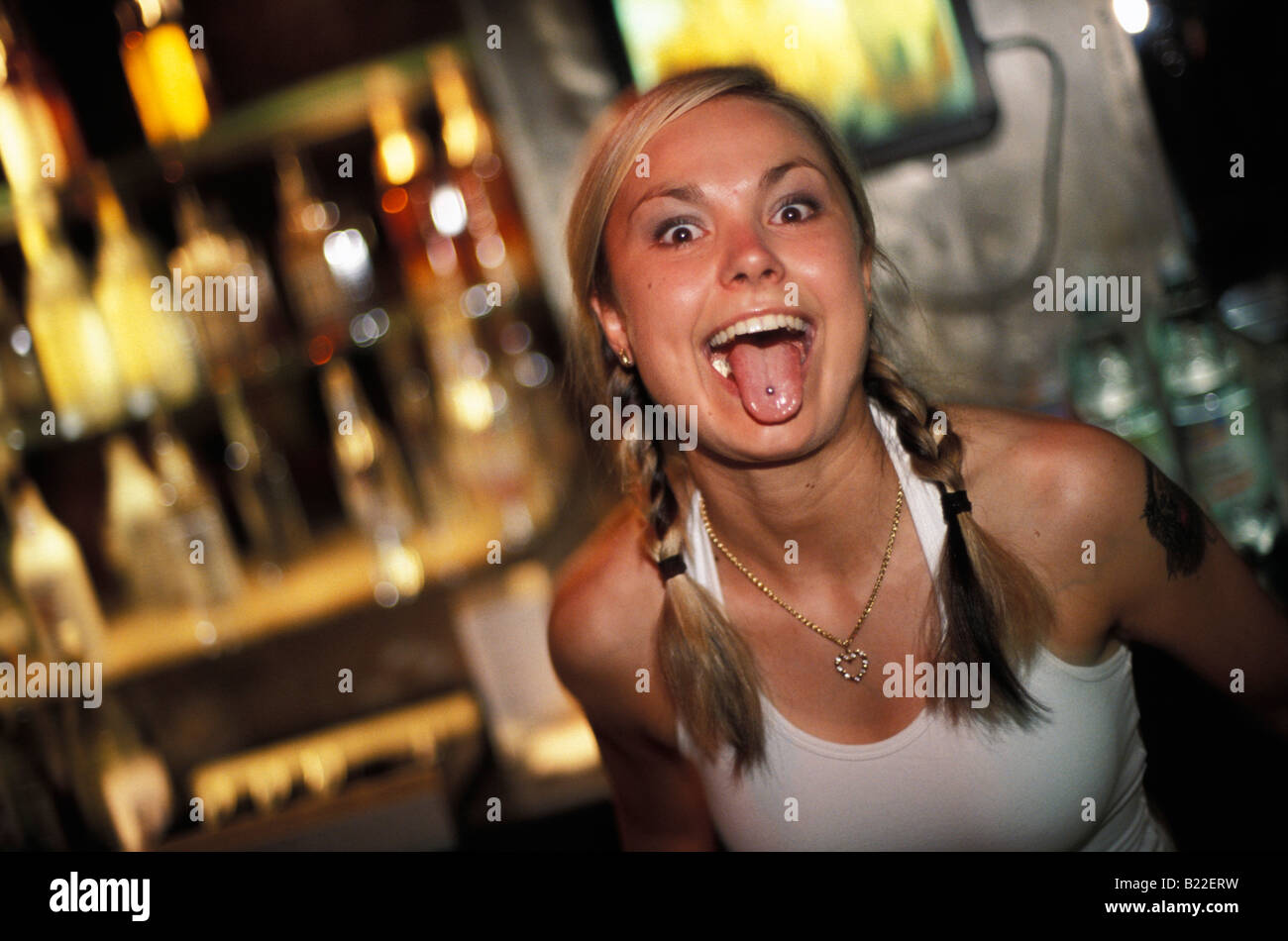 A young woman in a bar showing off her pierced tongue in Ground Zero Club Warsaw Poland Stock Photo