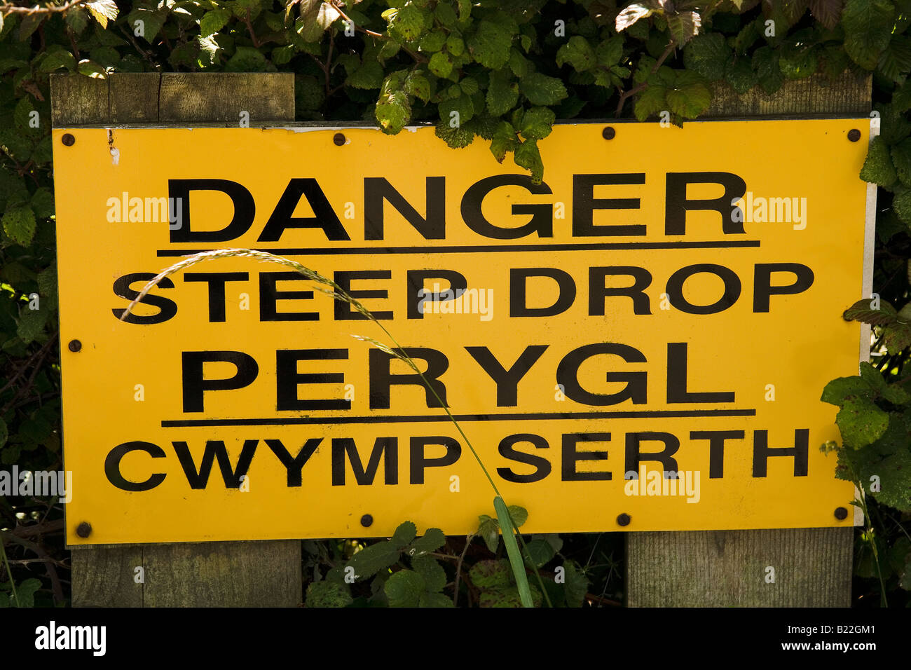 bi-lingual warning sign at cliff top Stock Photo