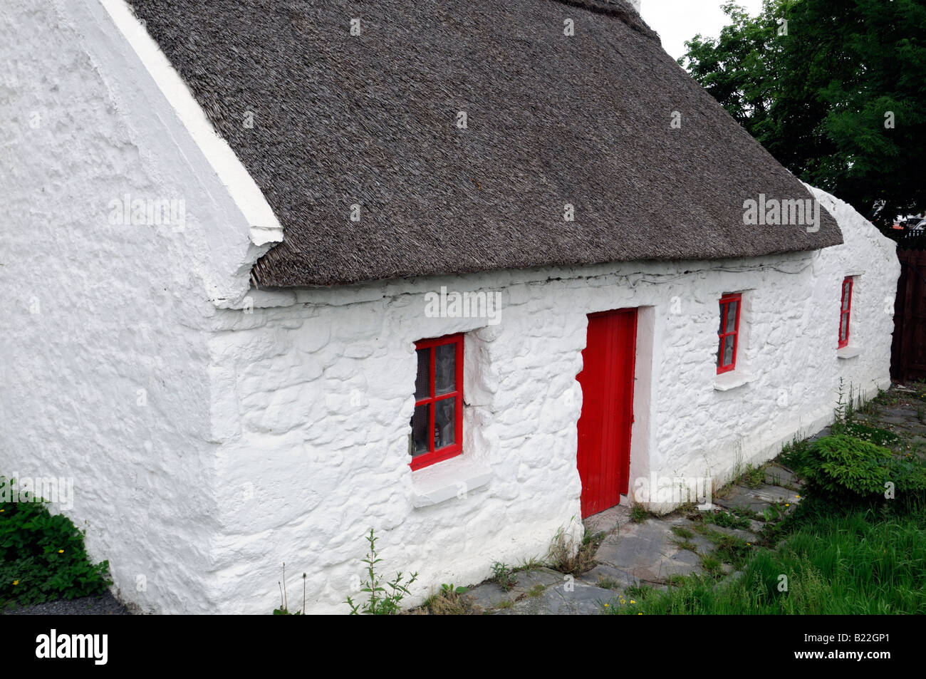 Thatched Roof Cottage With Red Painted Wooden Door And Window