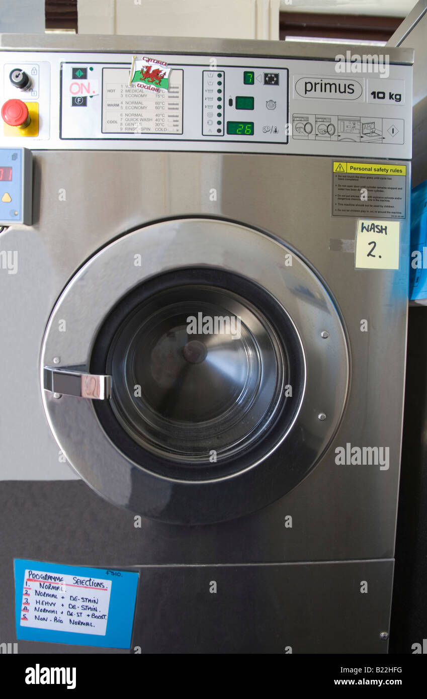 Close up of a front loading industrial size automatic washing machine in a laundry Stock Photo