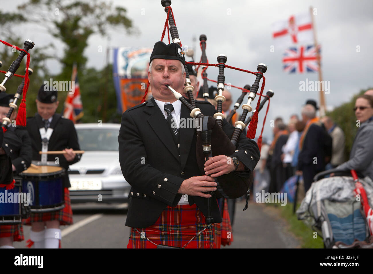 piper in pipe band marching down country road during 12th July