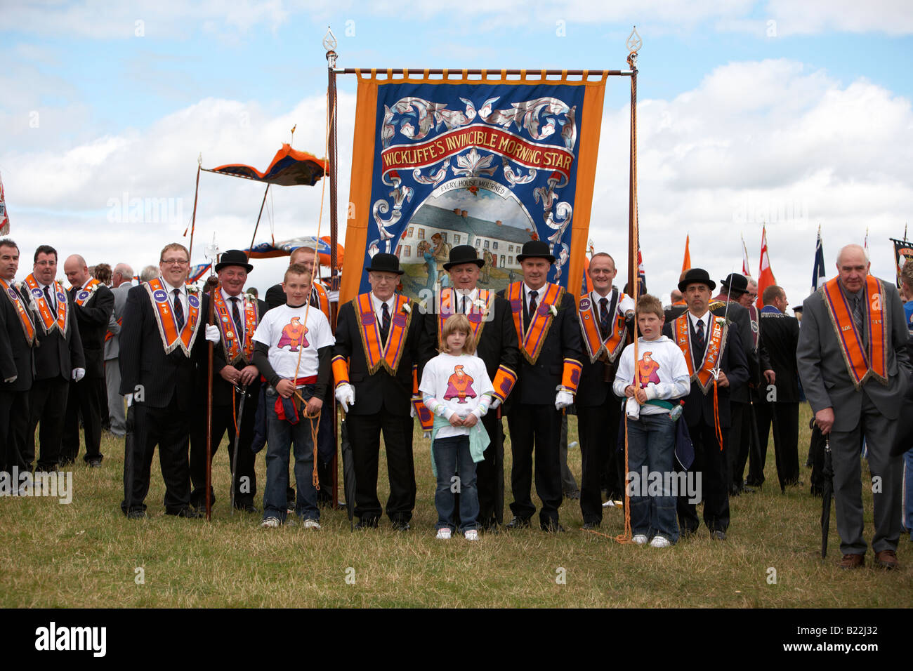 members of loyal orange order orangemen with banner in field during 12th July Orangefest celebrations in Dromara county down Stock Photo