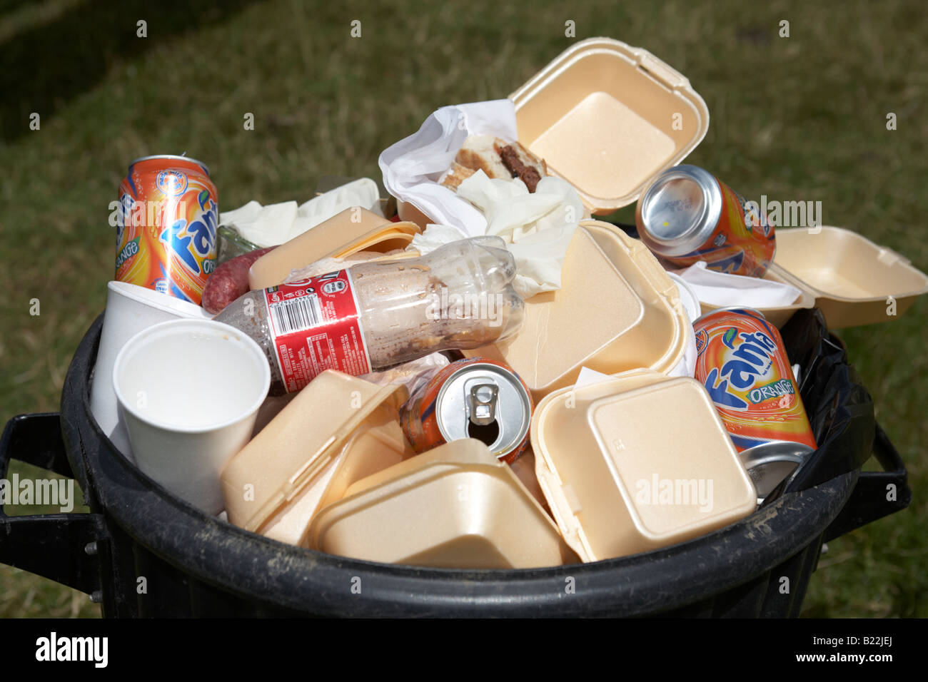 pile of litter abandoned styrofoam fast food containers in a bin in a field Stock Photo