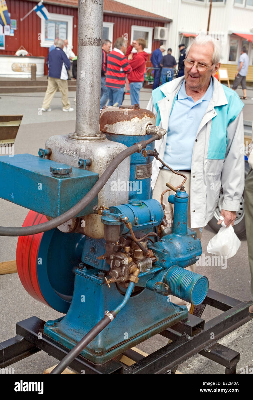 Elderly man looks at 'Skandia 23 A Marin' a hot bulb marine engine from 1930 Stock Photo