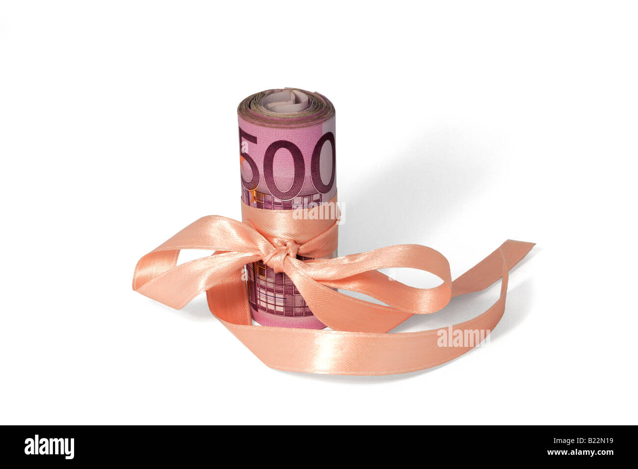 A roll of 500 Euro banknotes tied up with a pink silk ribbon. Silo image. Stock Photo