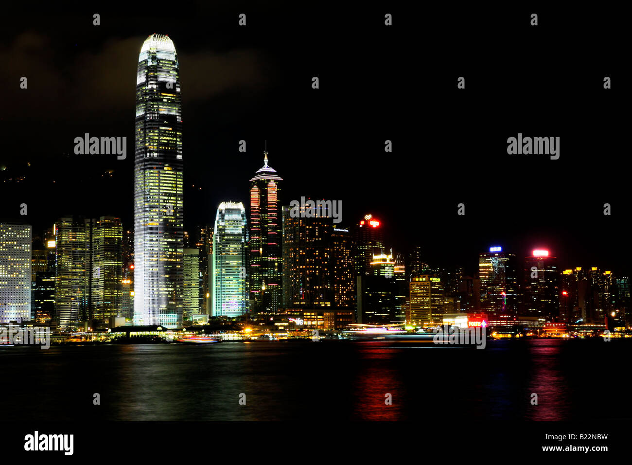 Hong Kong Island skyline at night with illuminated buildings and prominent IFC tower, viewed from the Kowloon mainland Stock Photo