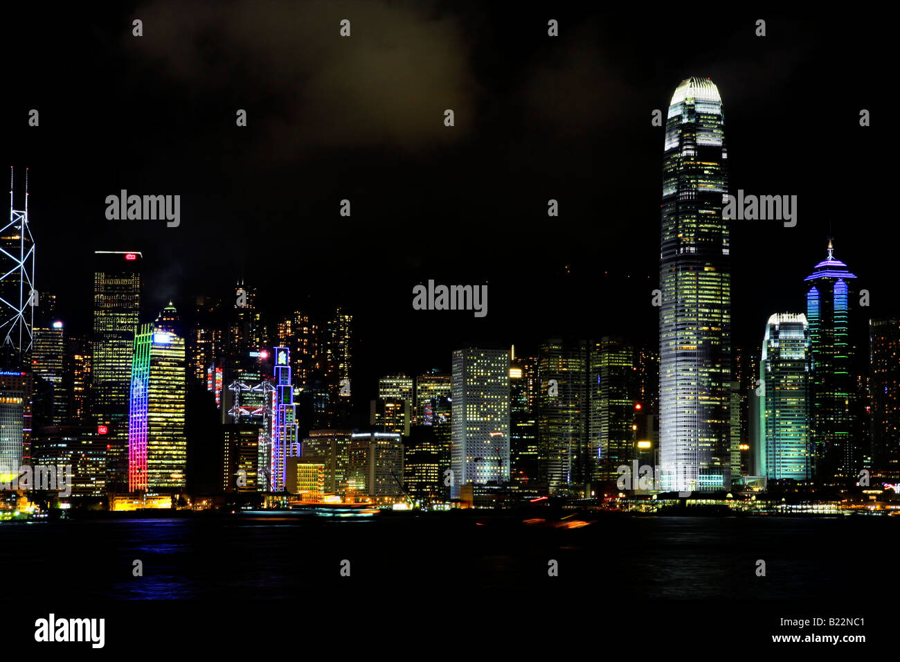 Hong Kong Island skyline at night with illuminated buildings and prominent IFC tower, viewed from the Kowloon mainland Stock Photo