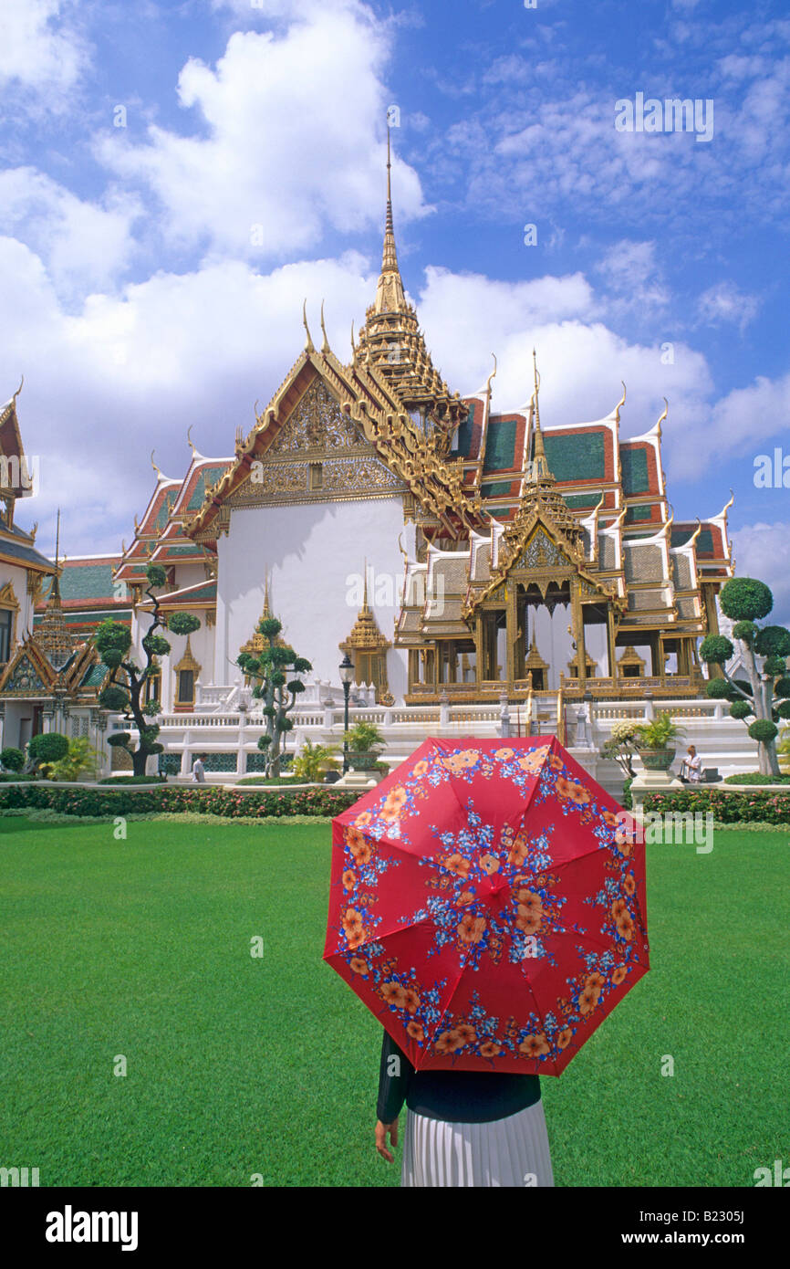 Tourist with umbrella in front of temple Wat Phra Kaeo, Grand Palace, Bangkok, Thailand Stock Photo