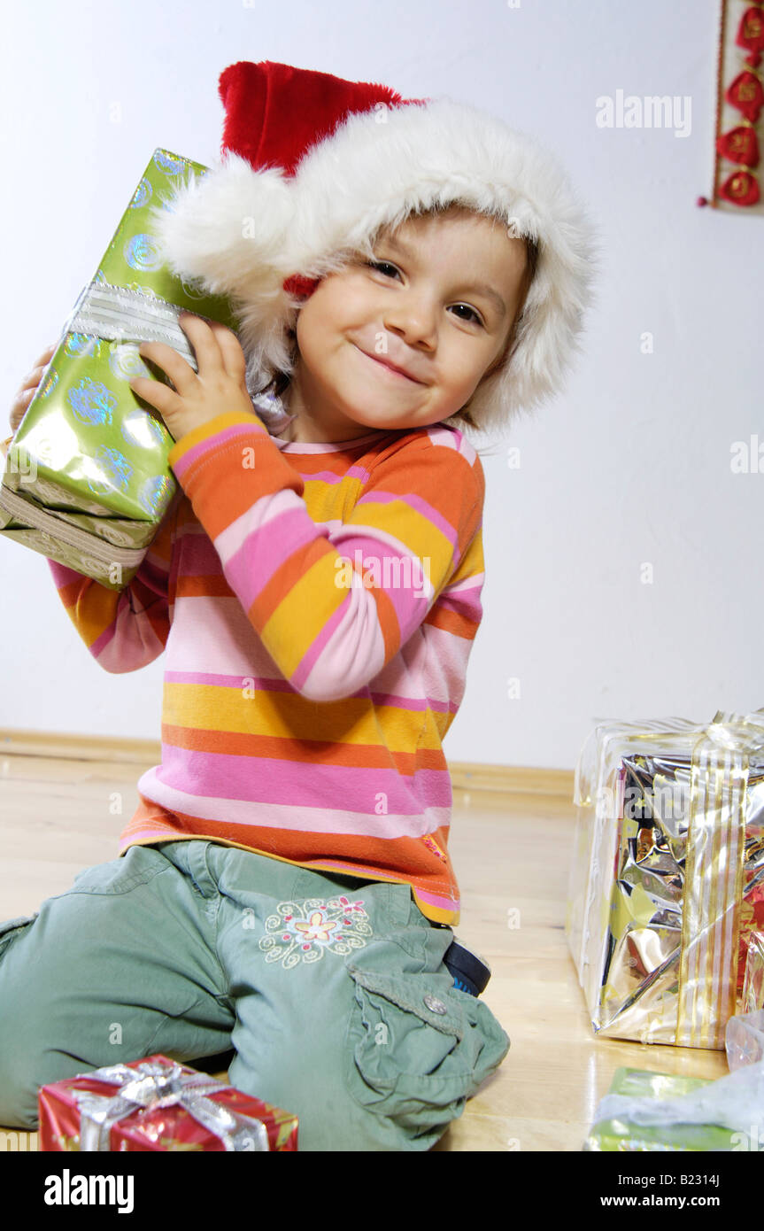 Portrait of girl holding christmas gift and smiling Stock Photo - Alamy