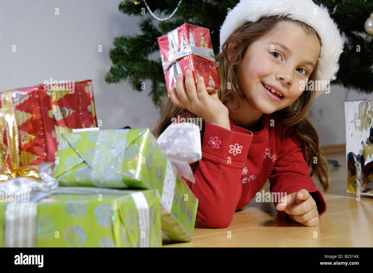 Portrait of girl holding christmas gift and smiling Stock Photo - Alamy