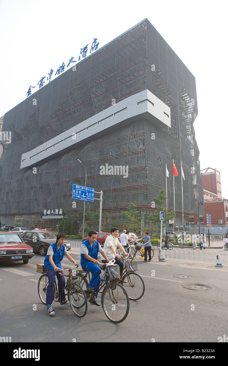 Cyclists on city road in front of building, China Stock Photo