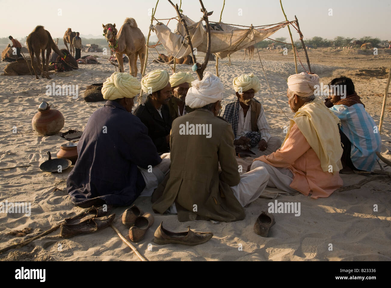 A group of men are seated in a circle in the early morning at the Tilwara livestock fair near Balotra, Rajasthan, India Stock Photo