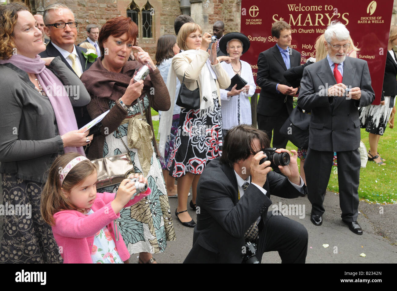 Family and friends gather to photograph a newly married couple Stock Photo