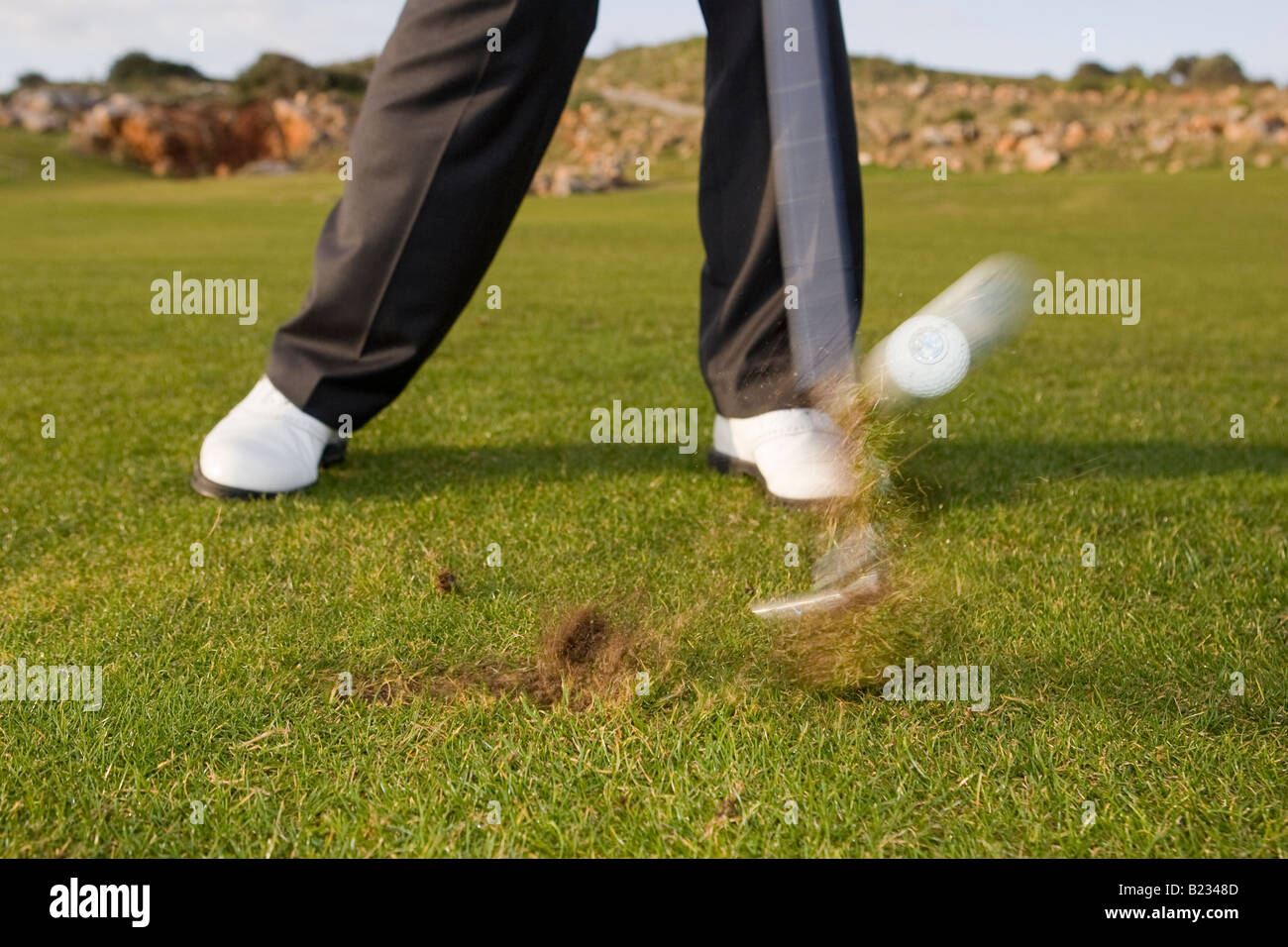 Golfer hitting ball off fairway and making a divot Stock Photo