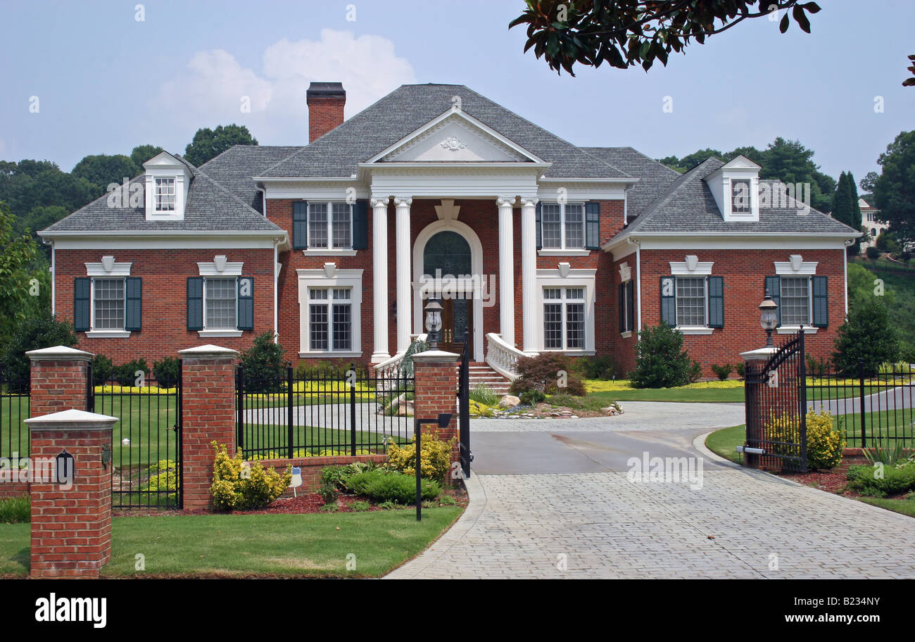 Large brick house behind iron gate Stock Photo Alamy