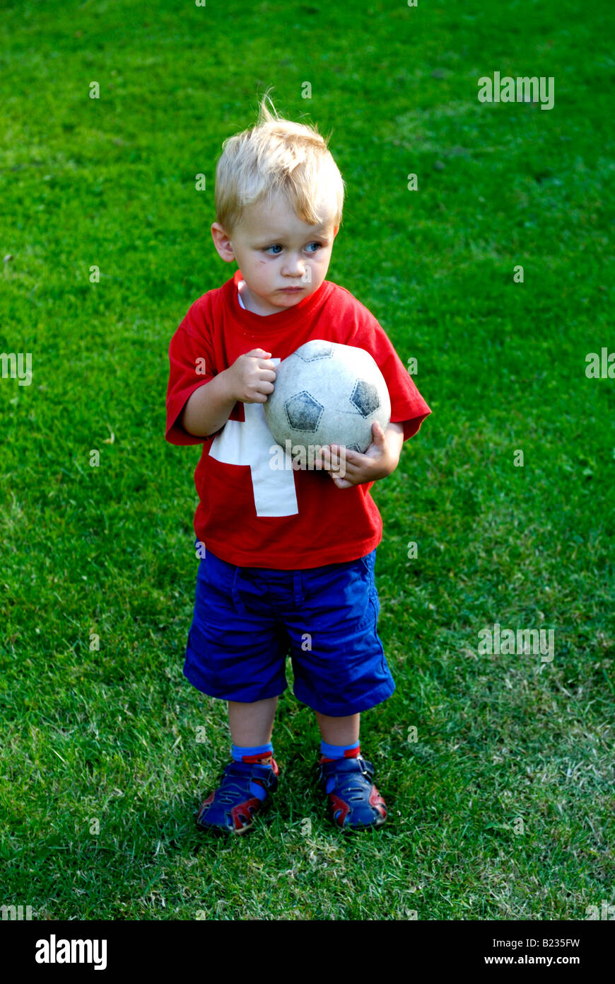 Very Young two years Soccer Player blond boy Holding Soccer Ball Stock Photo