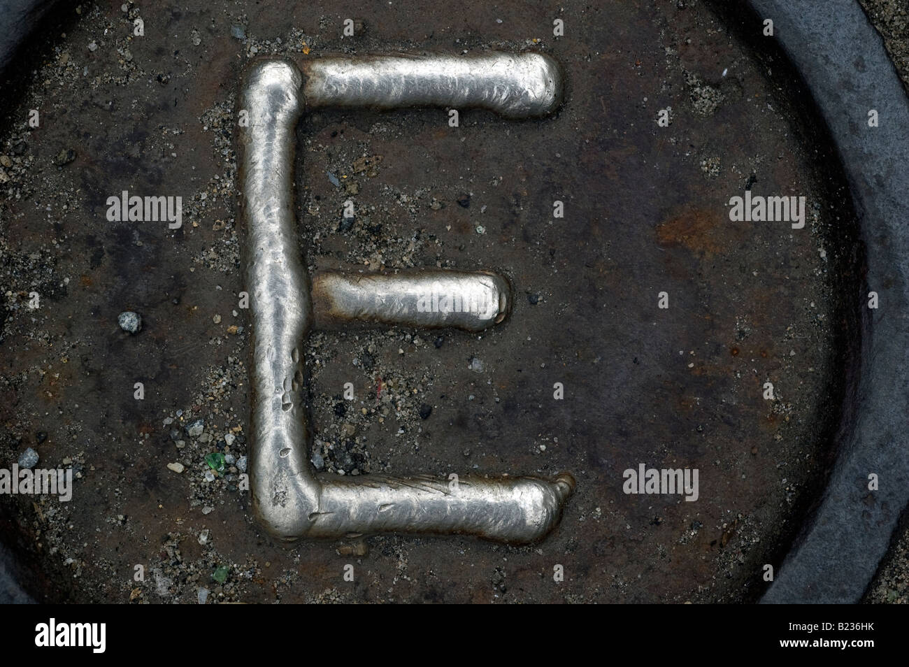 Close up of man hole cover with the letter E Stock Photo
