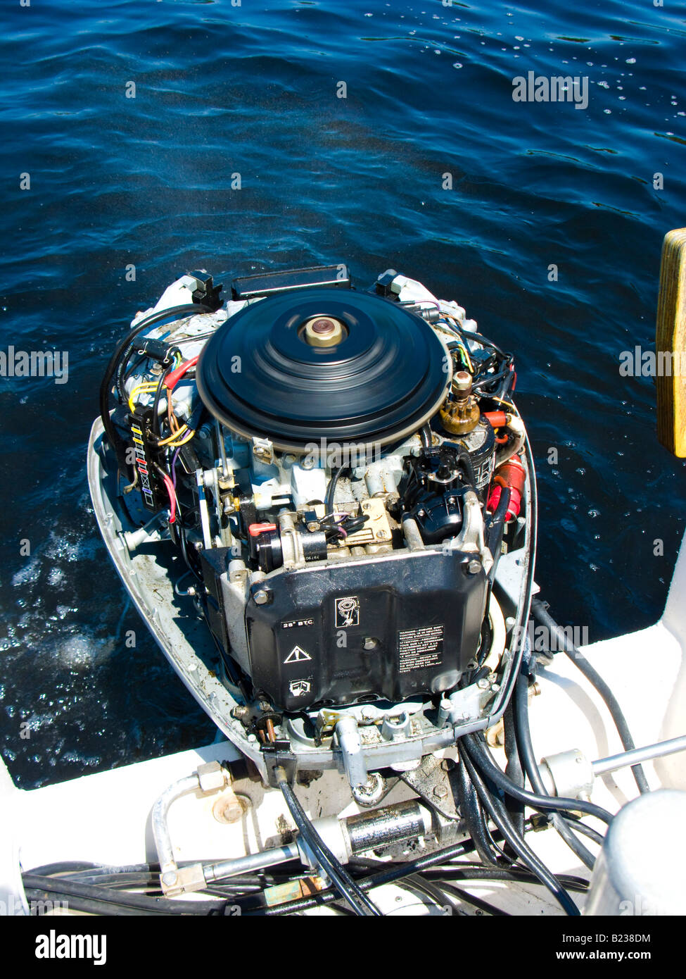 The flywheel spins on a marine outboard engine, exposed with the cover removed Stock Photo Alamy