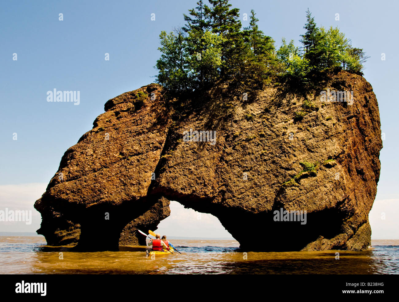 Canada New Brunswick Kayakers paddling through Hopewell Rocks at high tide Bay of Fundy Flower Pot Rocks Stock Photo