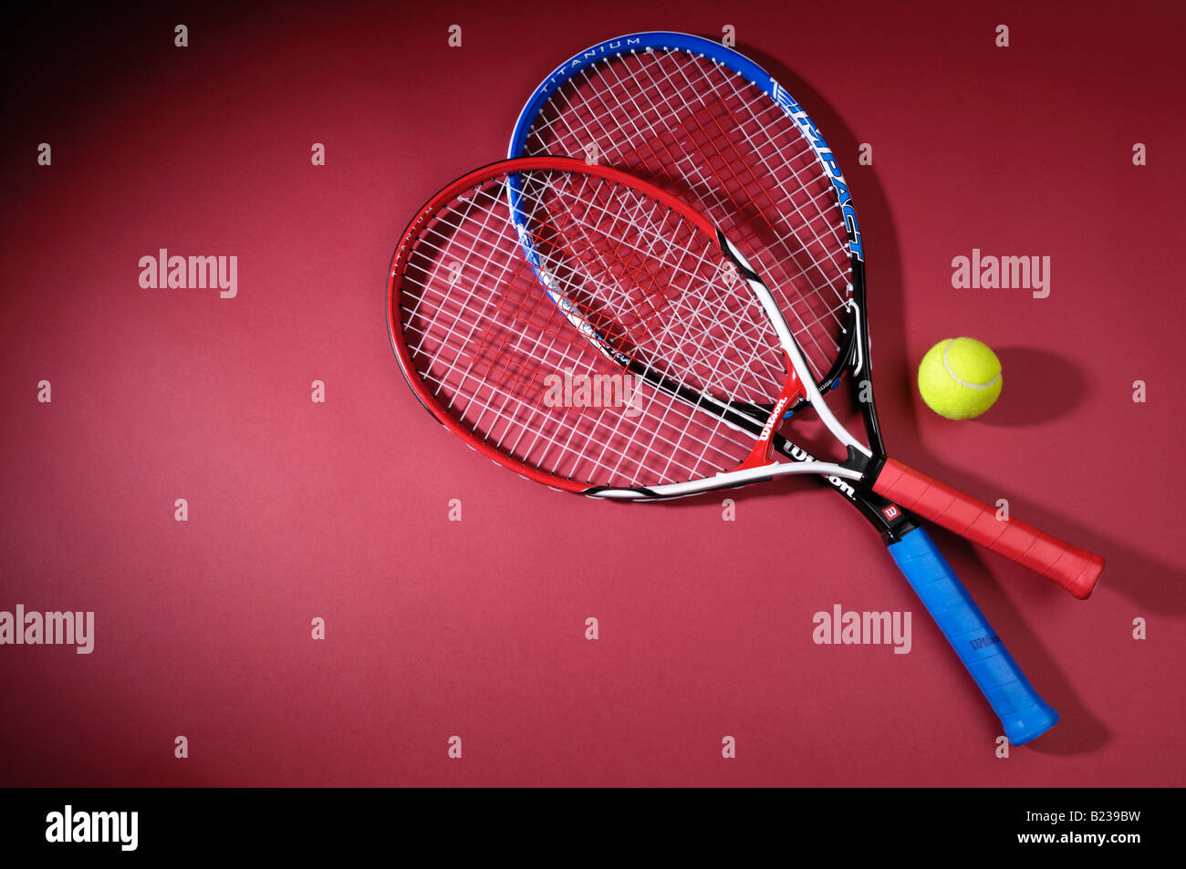 Tennis rackets and a ball isolated on red background Stock Photo