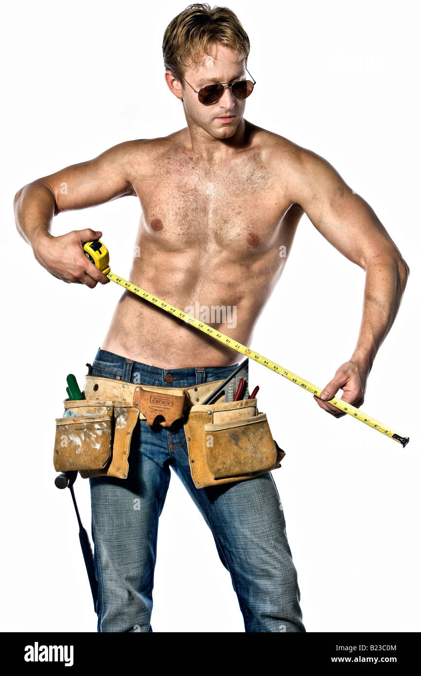 Sexy Caucasian Handyman Posing With His Toolbelt Wearing Aviator Sunglasses And Blue Jeans Stock