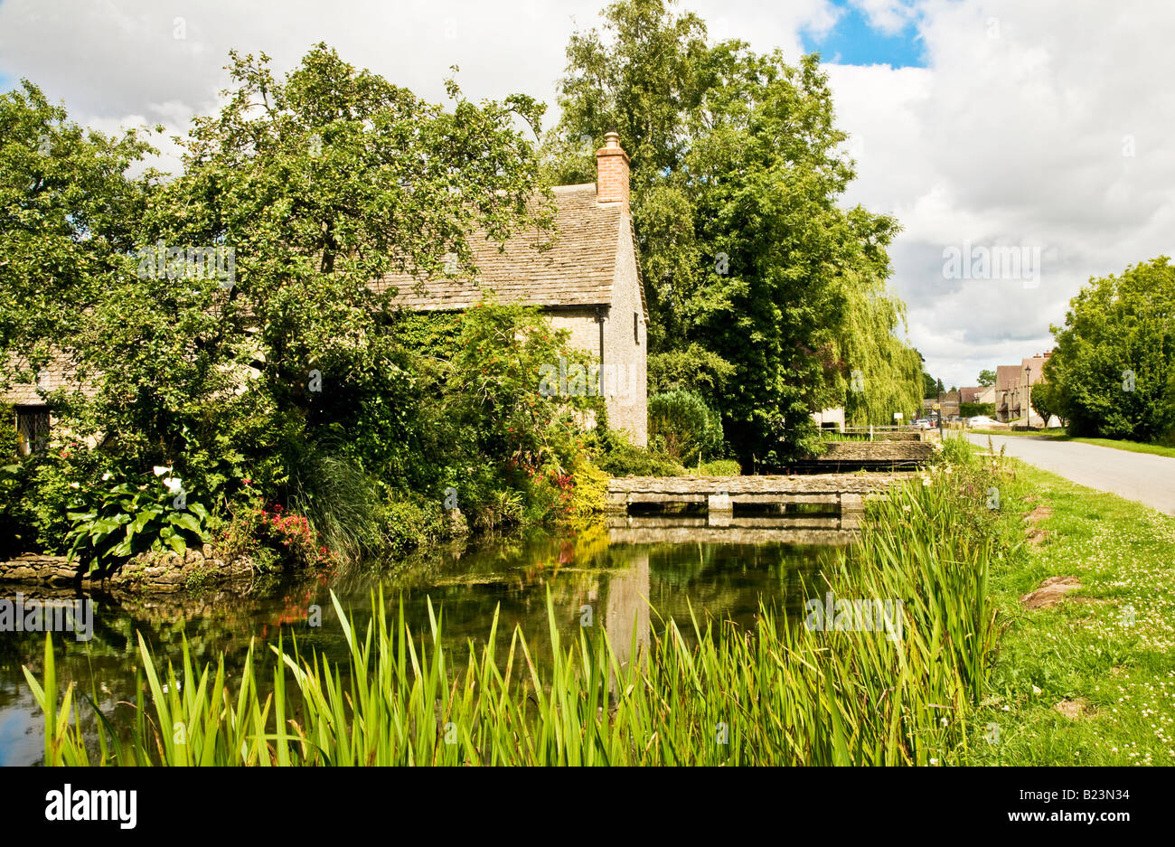 The infant River Thames flowing past village houses at Ashton Keynes