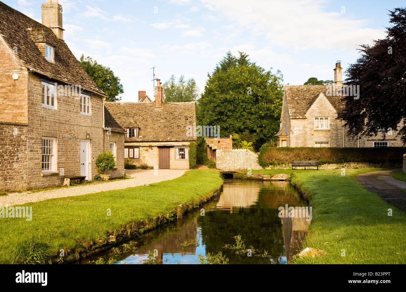 Typical English Cotswold village scene in summer with millstream and