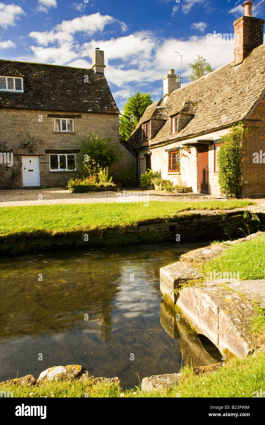 Cotswold stone country village houses by millstream in Church Walk, Ashton Keynes, Wiltshire, England, UK Stock Photo