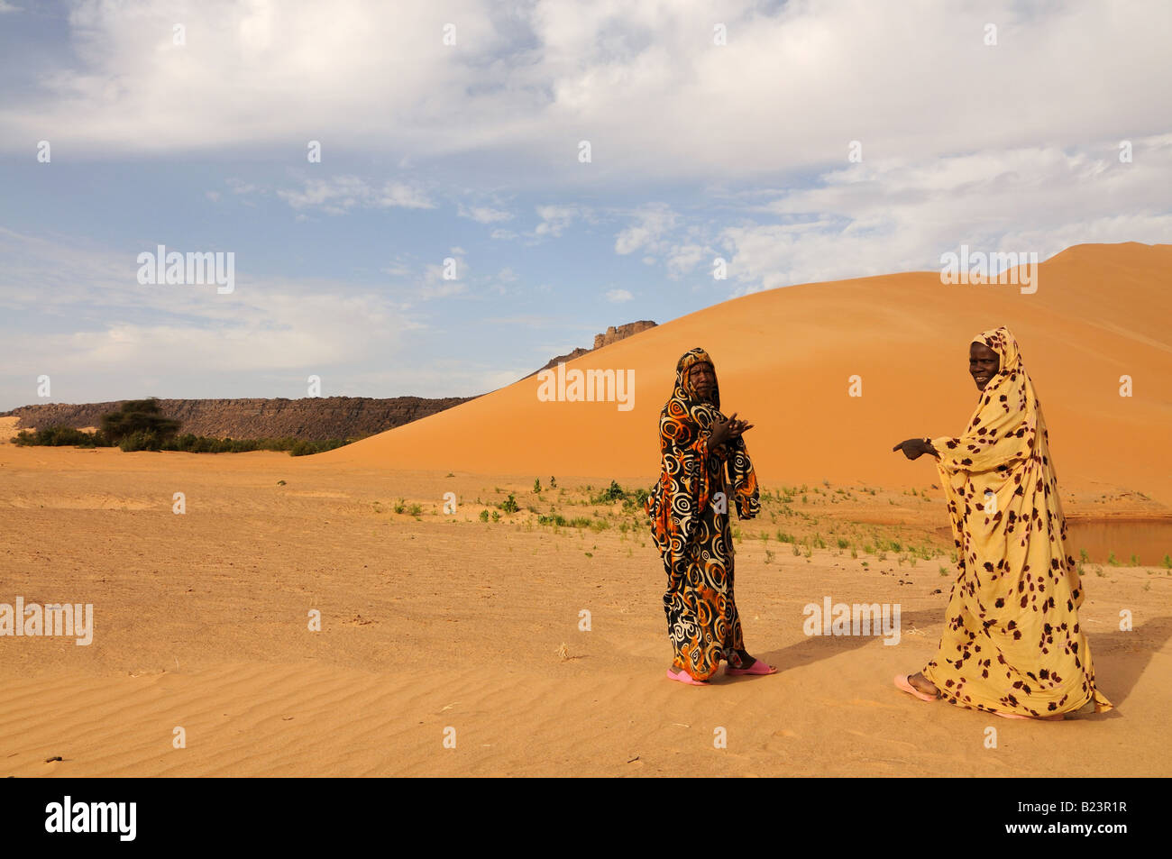 Bedouin women before Giant sand dune in the Sahara near Atar Western Africa Mauritania Africa Stock Photo