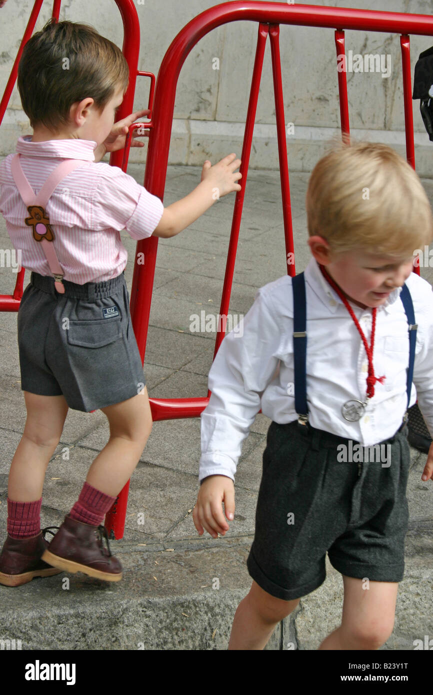Children dressed in 'lederhosen' playing during semana santa, seville, spain Stock Photo