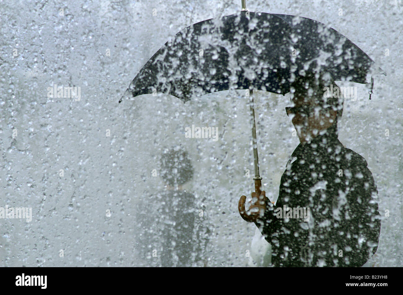 man with umbrella during very heavy downpour, rainstorm in London Stock Photo
