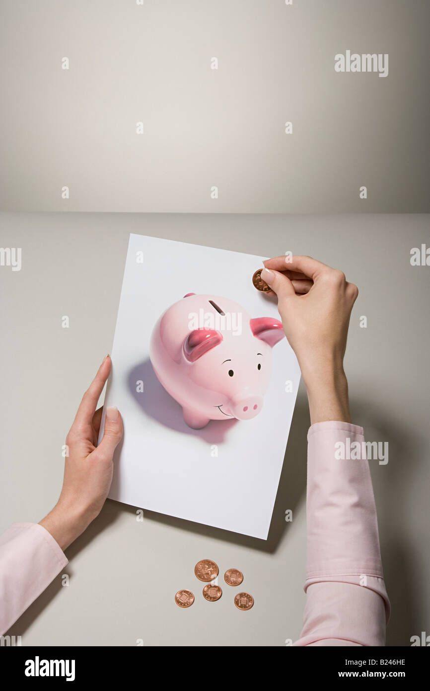 A woman holding a photograph of a piggy bank and money Stock Photo - Alamy