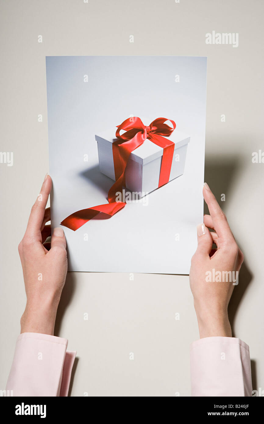 A woman holding a photograph of a gift Stock Photo