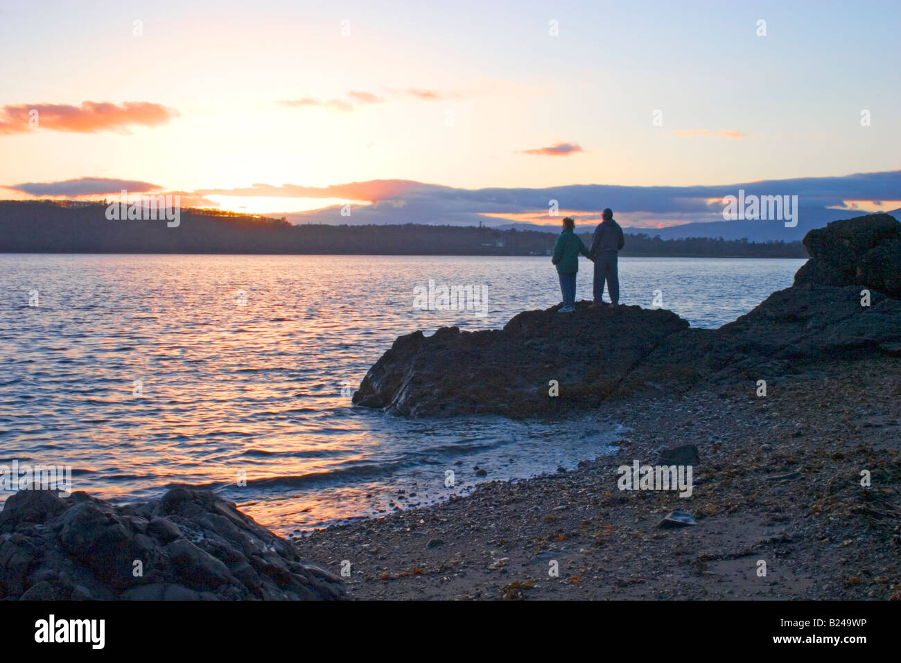 Two people watching sun setting hi-res stock photography and images - Alamy