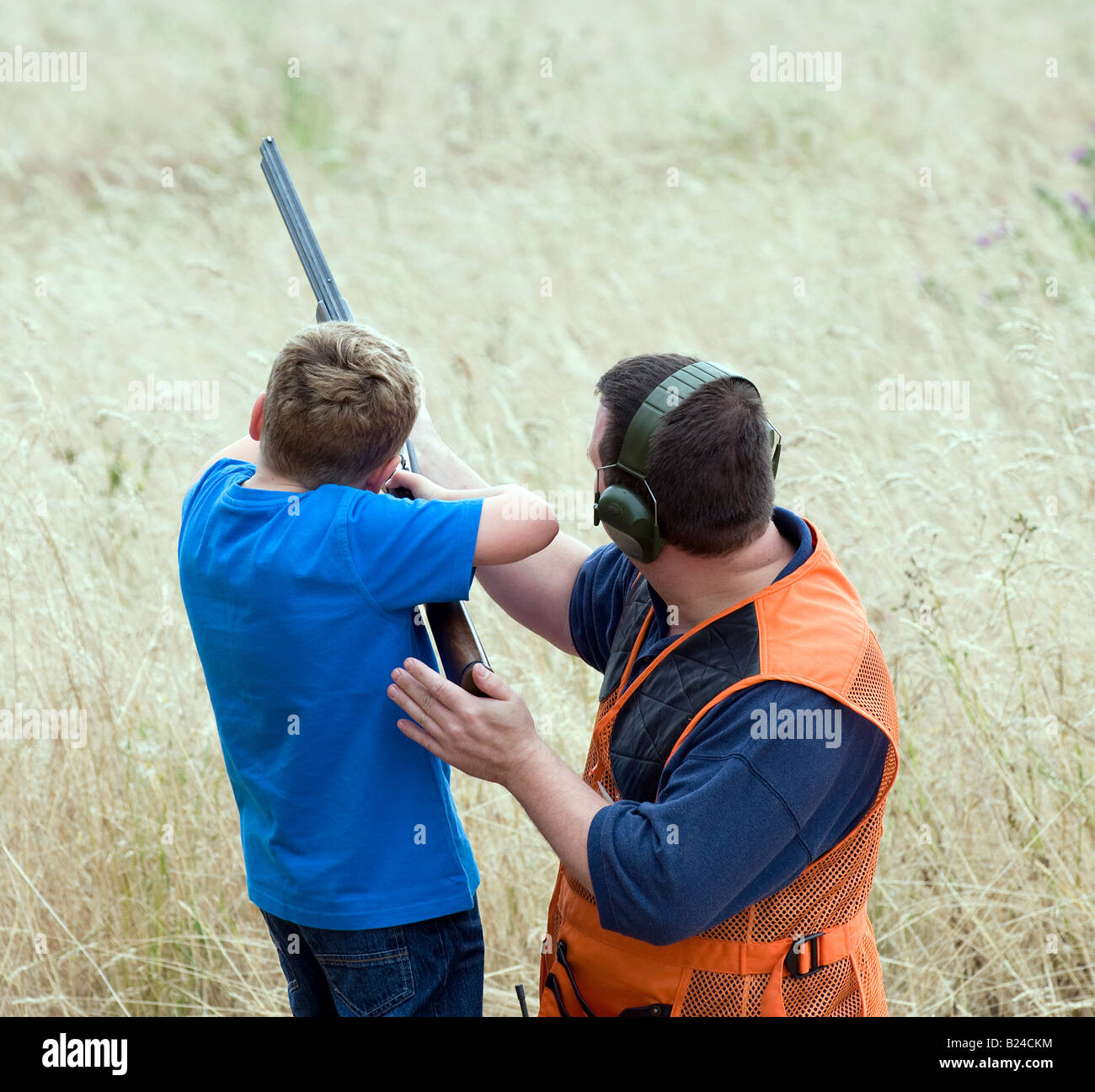 Teaching a young person how to safely use a shotgun for clay pigeon shooting Stock Photo