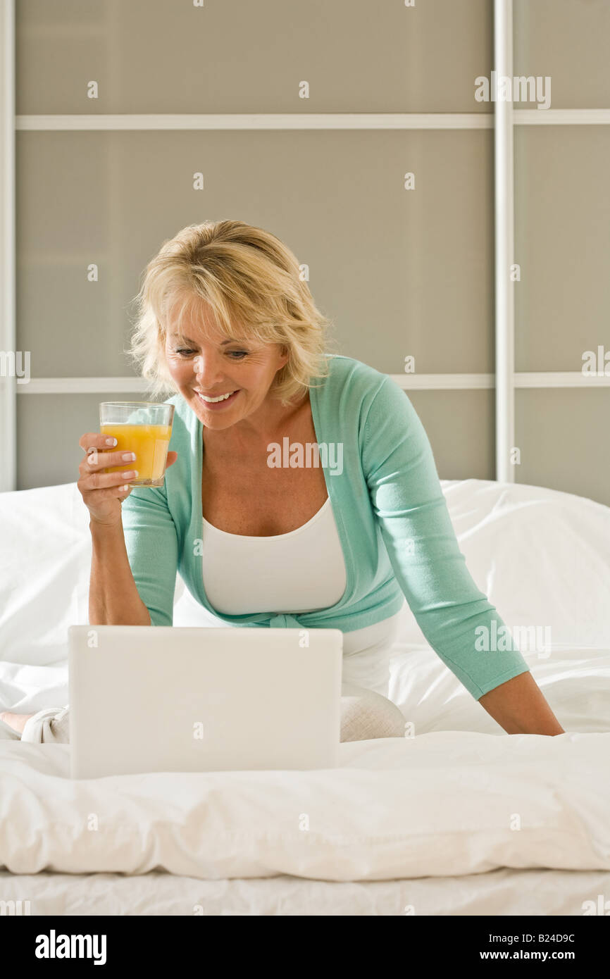 Woman on bed with laptop Stock Photo - Alamy