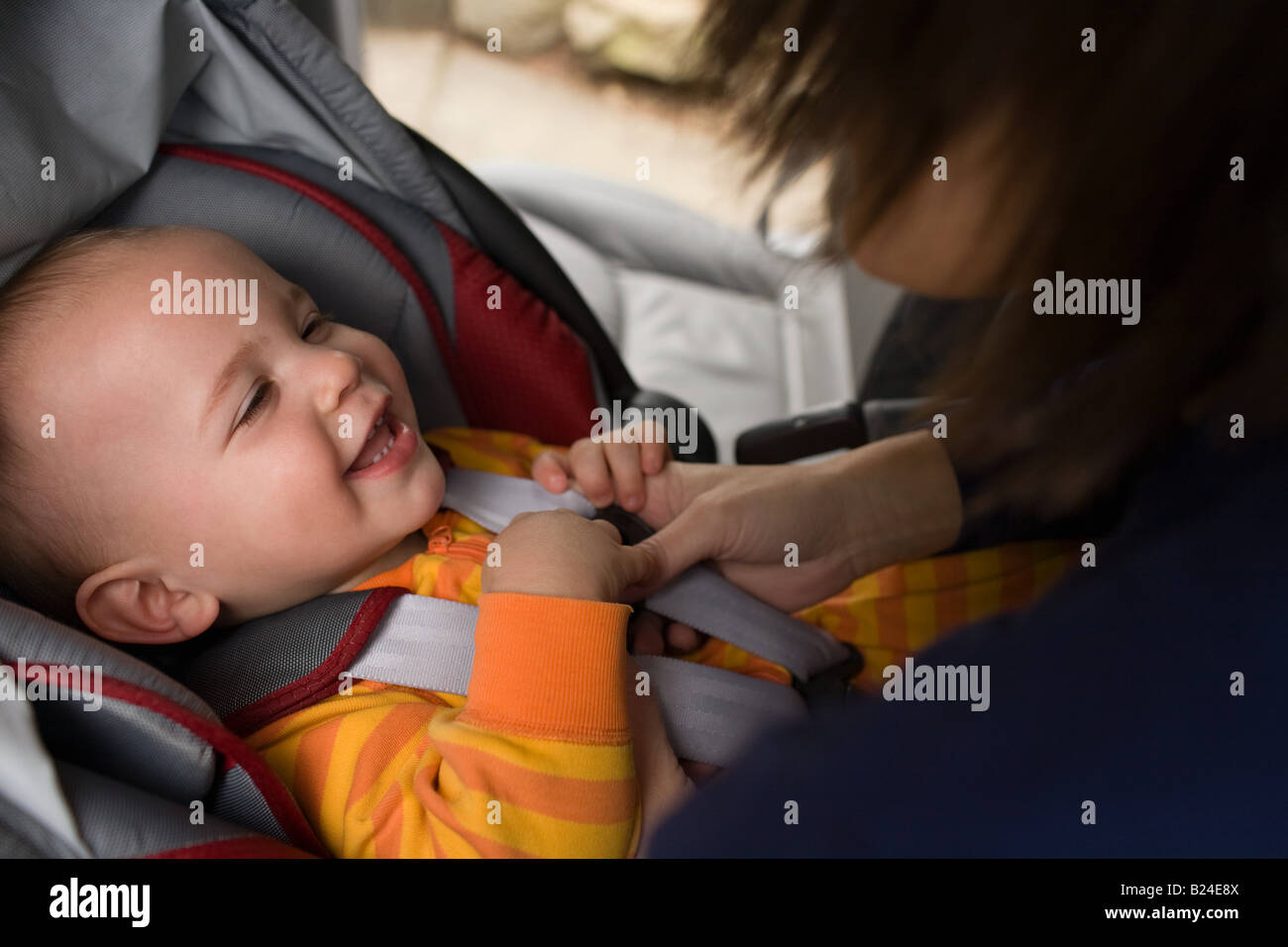 Mother putting baby in car seat Stock Photo Alamy