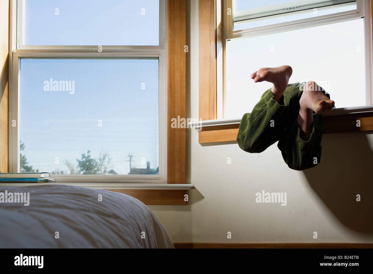 Boy climbing out of window Stock Photo Alamy