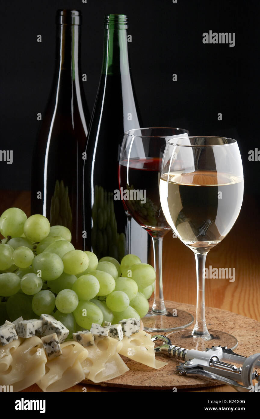 still life with grape cheese red and white wines on the black background Stock Photo