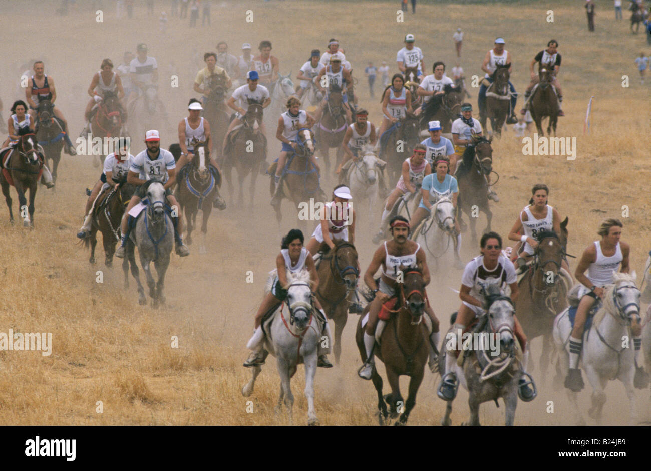 A large group of contestants in a Ride Tie horse racing and running competition start a long race across the hills near San Jose Stock Photo