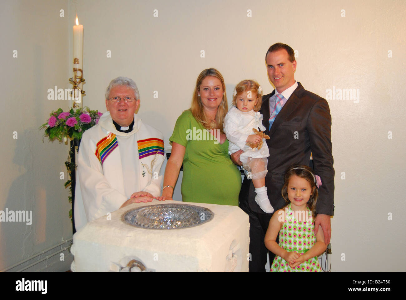 Family group with priest at Catholic christening, Sunninghill